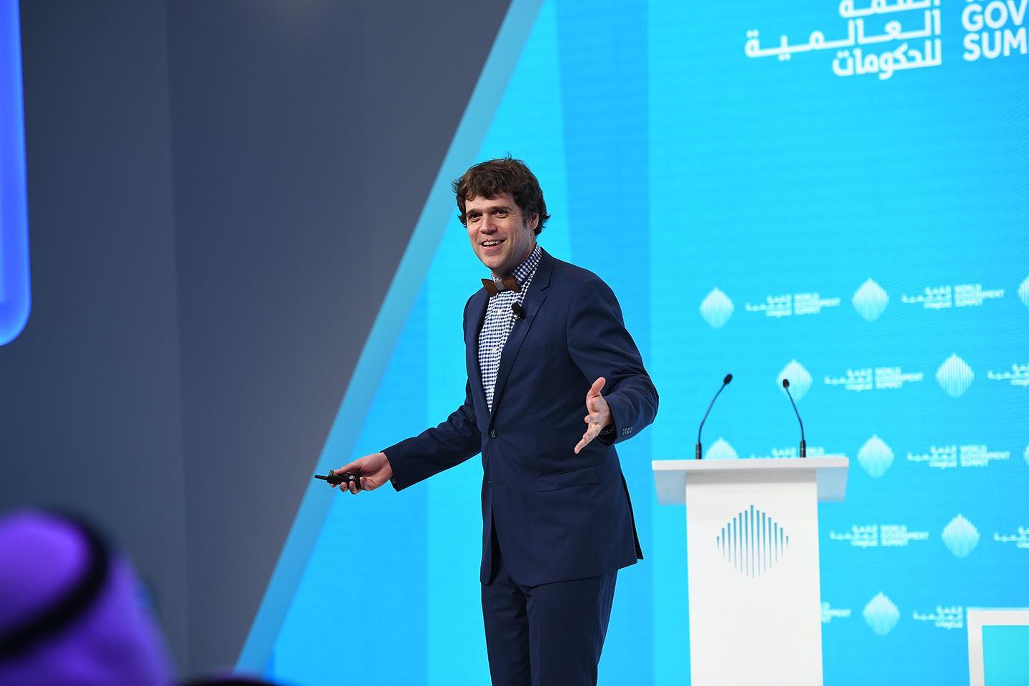 a young business man giving speech behind of a big screen